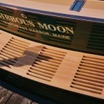 Boat named “Furious Moon” docked, showing wooden seat and green hull.